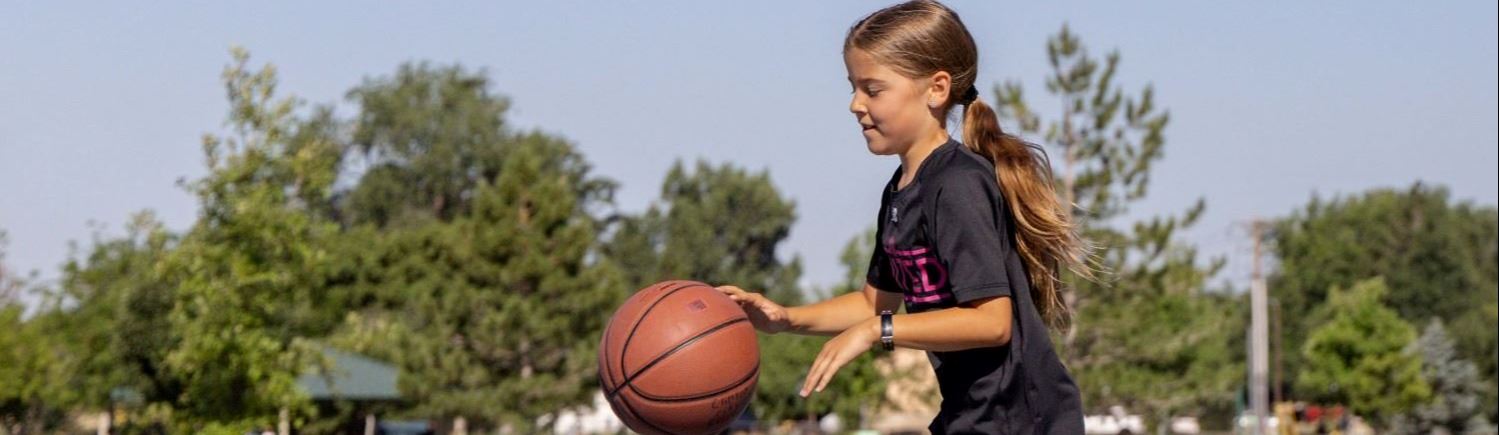 A girl dribbling a basketball