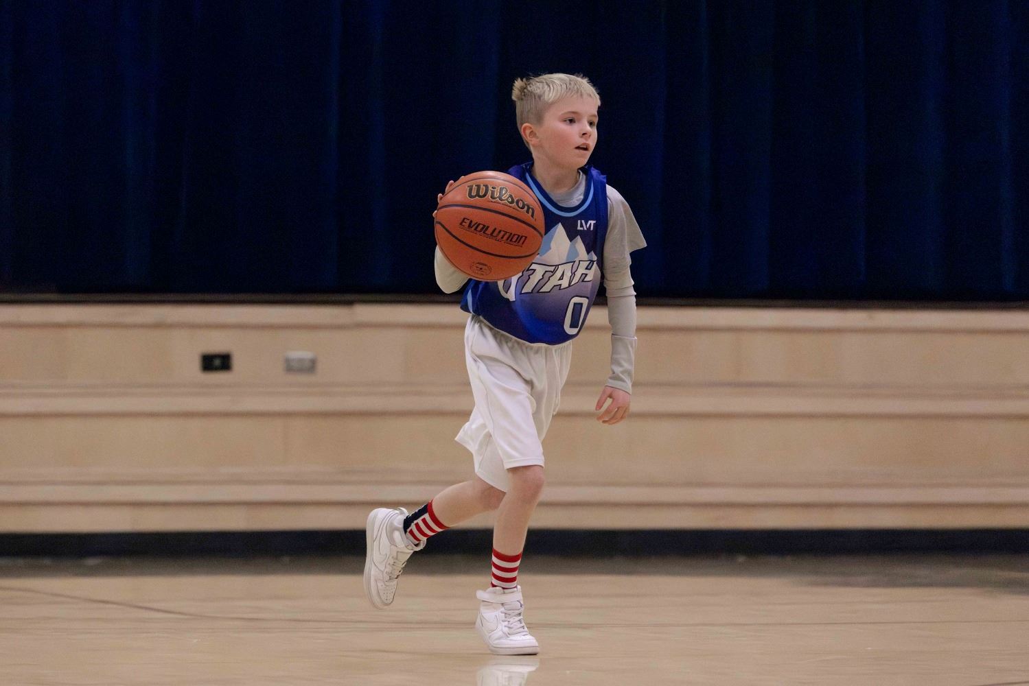 a boy dribbling a basketball